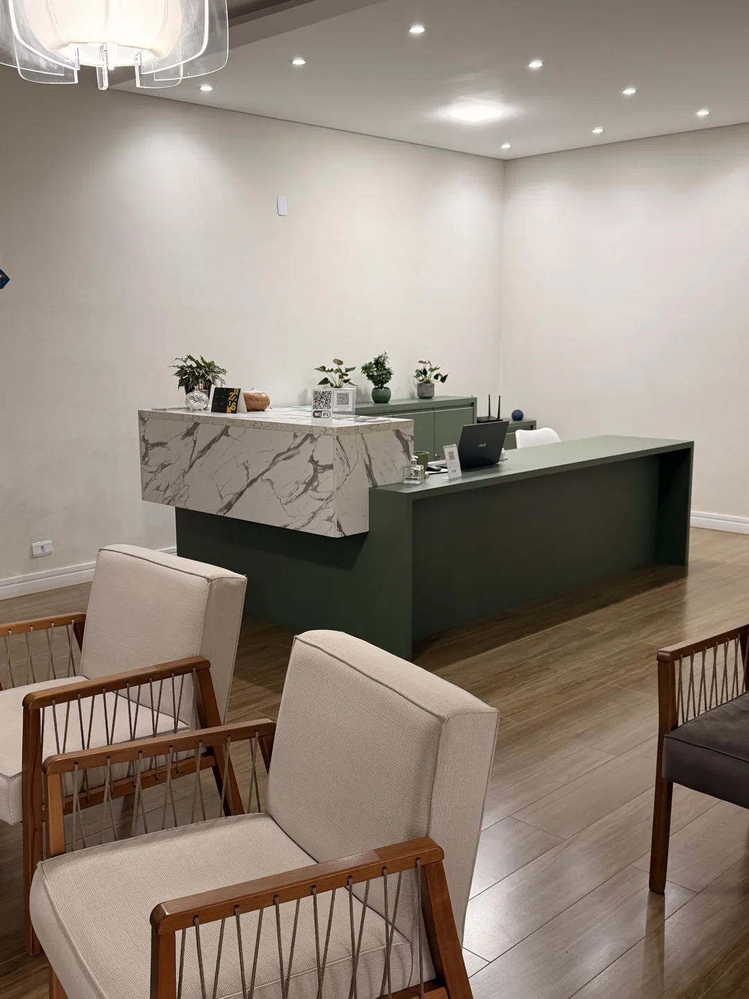 Recepção da Clínica Luz, com poltronas e balcão.