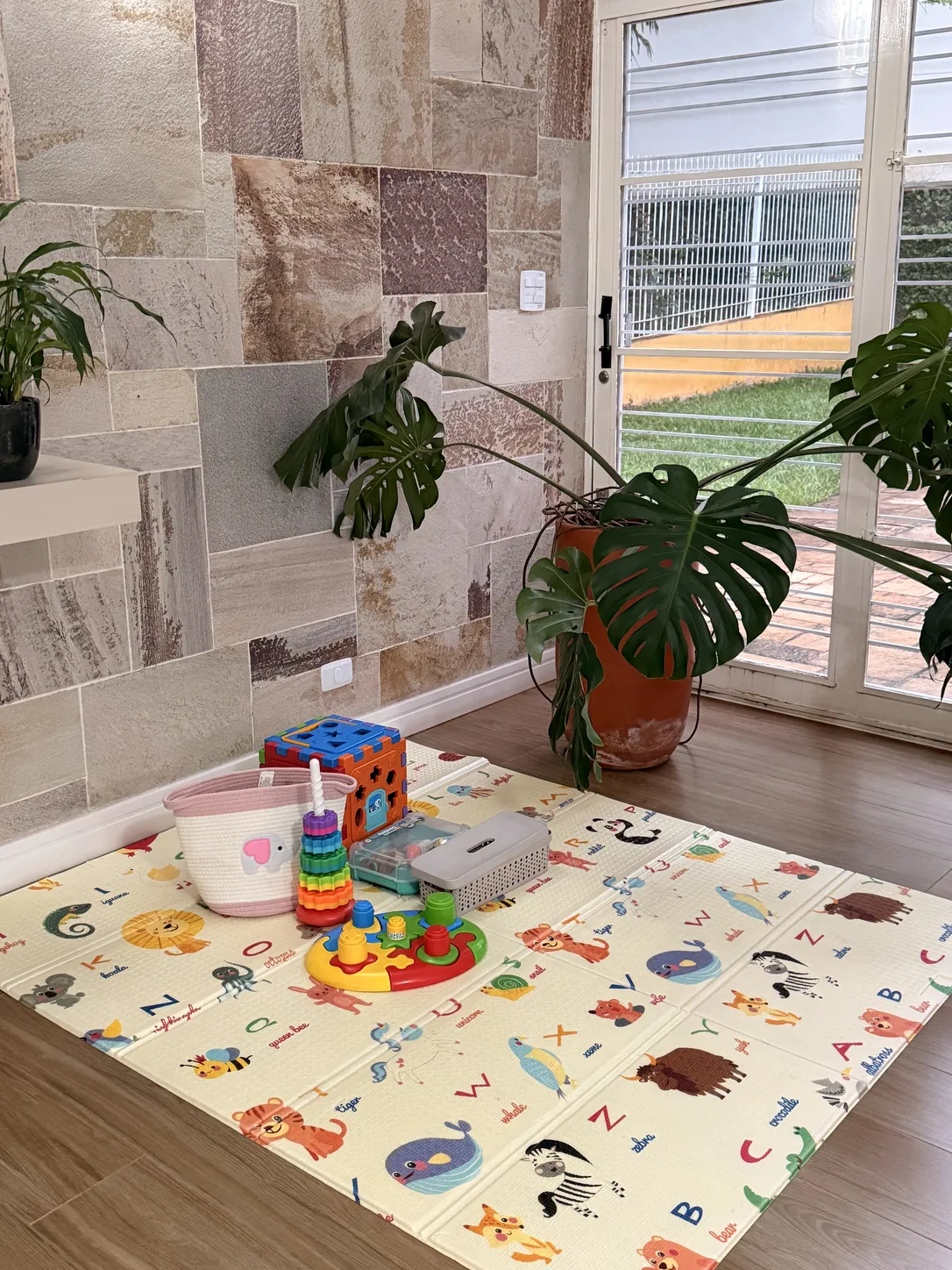 Espaço kids com tapete infantil e brinquedos na Clínica Luz, em Americana.